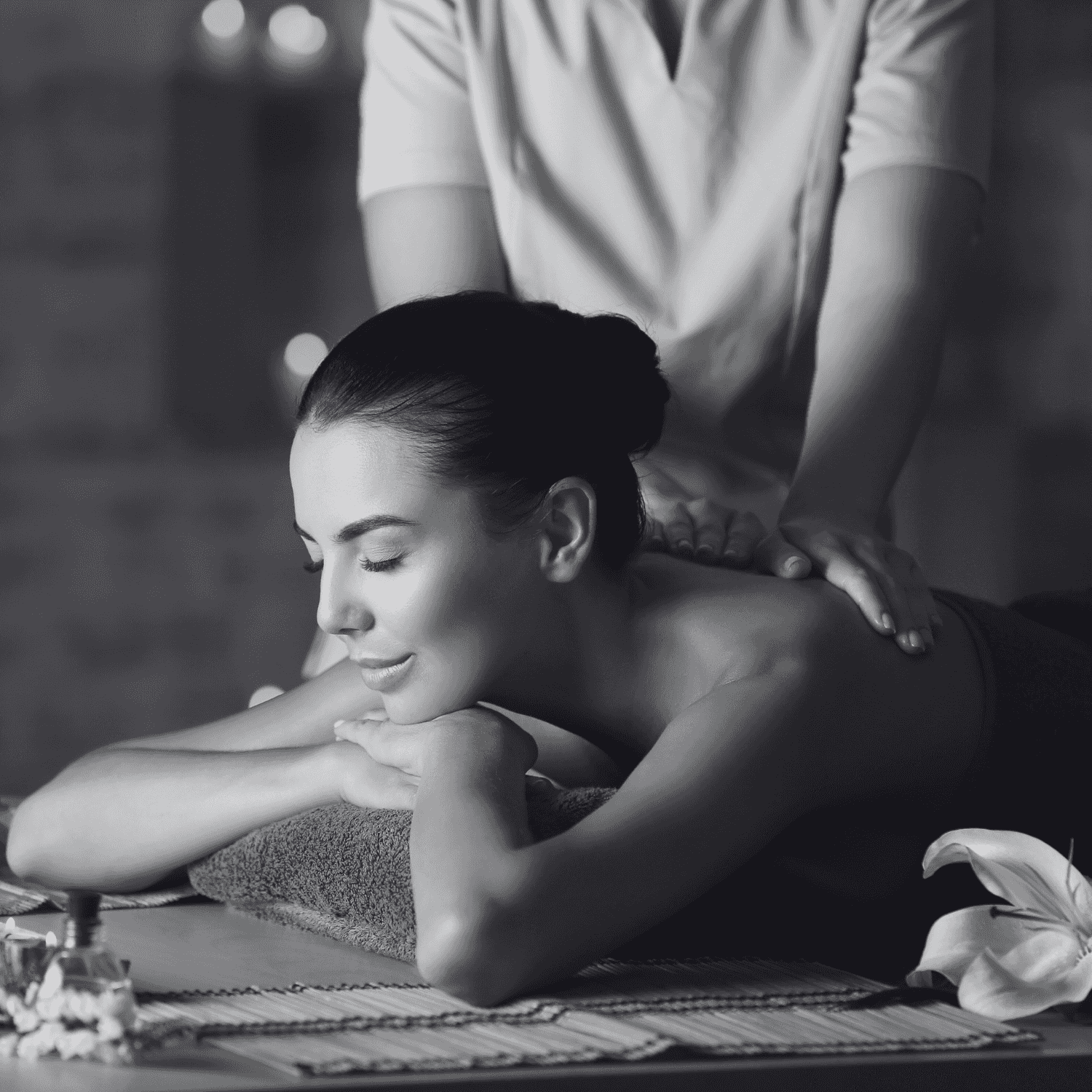 Woman receiving a relaxing back massage in a spa setting, lying on a massage table with a smile.